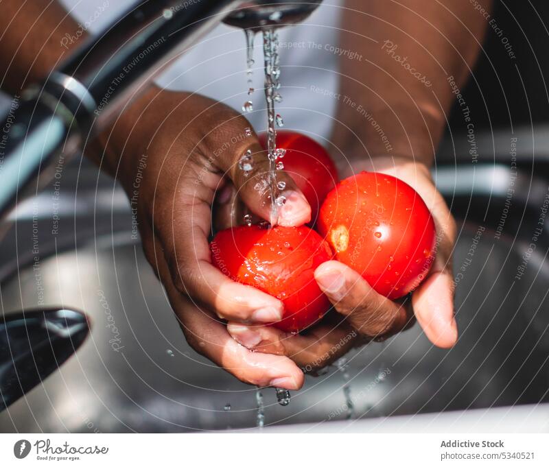 Anonymous man washing bell pepper during cooking preparation kitchen sink water prepare vegetarian fresh healthy food focus tap housework young vegetable home