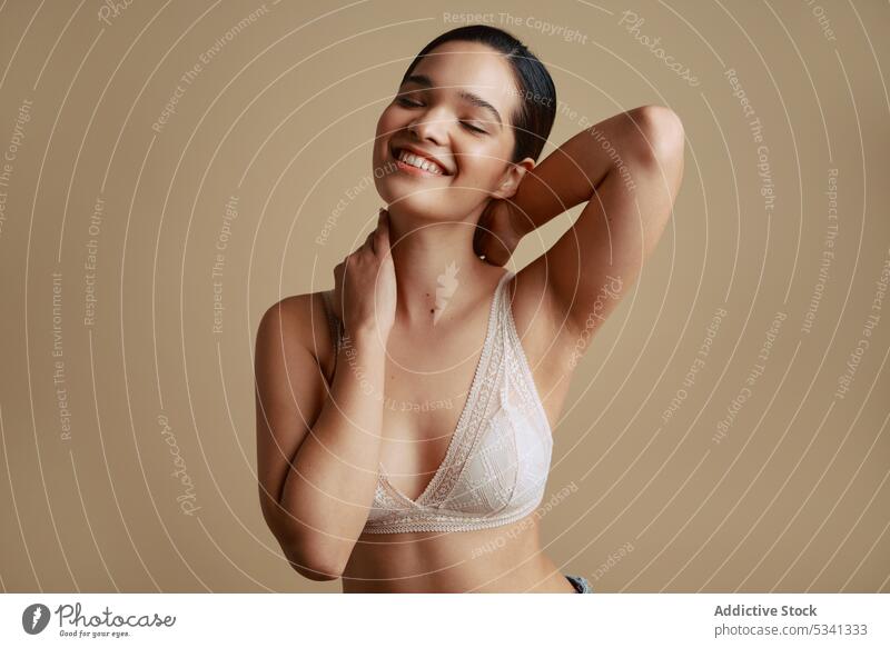 Smiling woman in underwear touching face and looking away - a Royalty Free  Stock Photo from Photocase