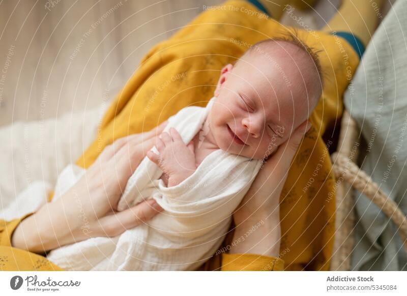 Cute baby smiling in hands of loving mother woman child sleep smile wicker bedroom happy love tender childhood home basket adorable infant cute mom parent