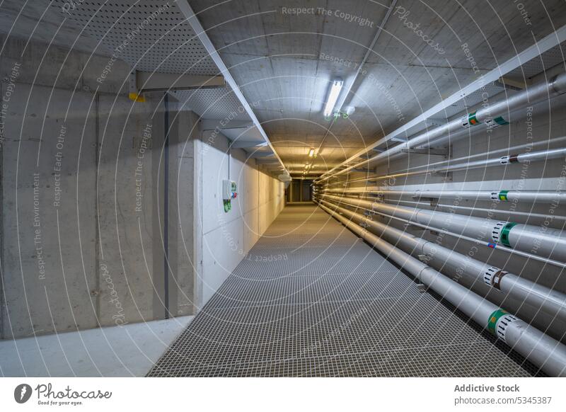 Empty underground tunnel with plumbing pipes corridor water gas pipeline drain system engineering hall basement warehouse boiler heat hvac ventilate electric