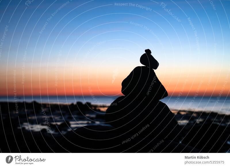 Stone pyramid on the Baltic Sea with a view of the sea at sunset and blue hour stone silhouette ocean pile of stones vacation sky coast art beach relaxation