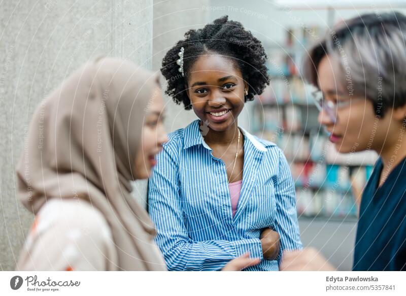 Group of multiethnic students having a discussion in a library real people teenager campus positive exam knowledge confident academic adult lifestyle academy