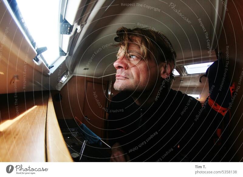 Examining view through the hatch in the ship Sailing ship Interior shot Man Blonde Looking Hatch Colour photo Human being Adults