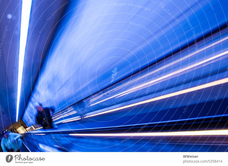 Dynamic lines of light race towards a vanishing point in a blue tunnel Blue Tunnel Escalator Shaft ascent hazy fast and furious Movement swift Speed blurriness