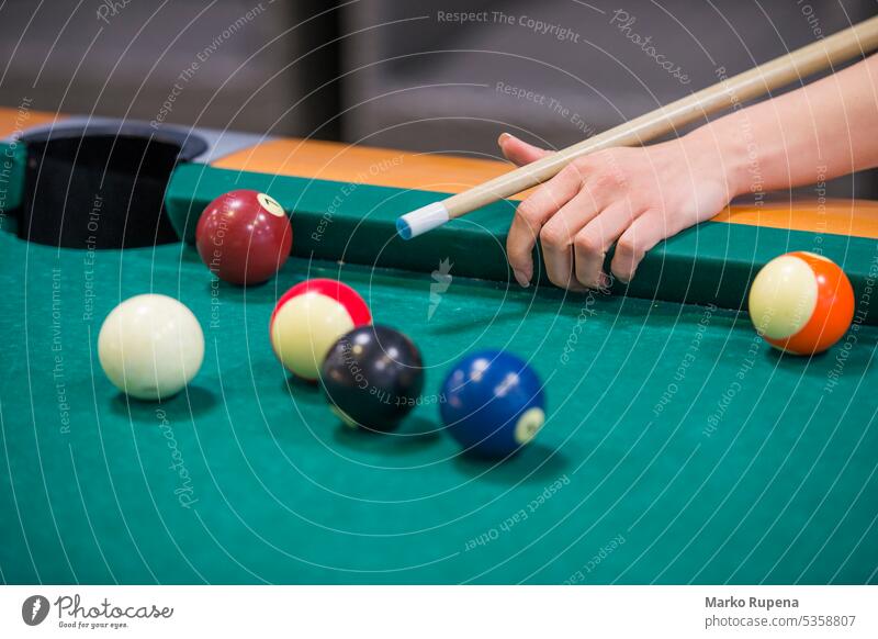 Woman playing billiard game on a pool table hand ball cue chalk green object leisure challenge aiming holding sport equipment competition club stick
