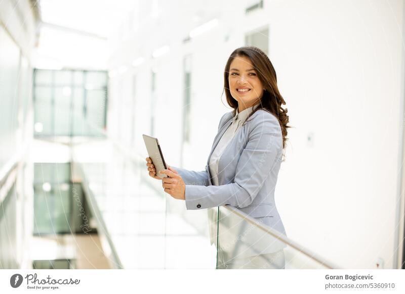 Young woman working on digital tablet in the office hallway gadget caucasian happy employee professional executive businesswoman female contemporary person