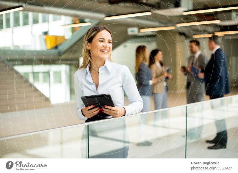 Young business woman with digital tablet in the office hallway project employee businesswoman businessman team people job career occupation enterprise
