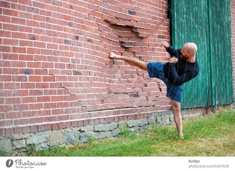 Martial arts enthusiast kicks in a brick wall Arise Force Footstep Brick wall Karate Fighter Combat sports Kick Brick facade Broken Annihilate corrupted Tread