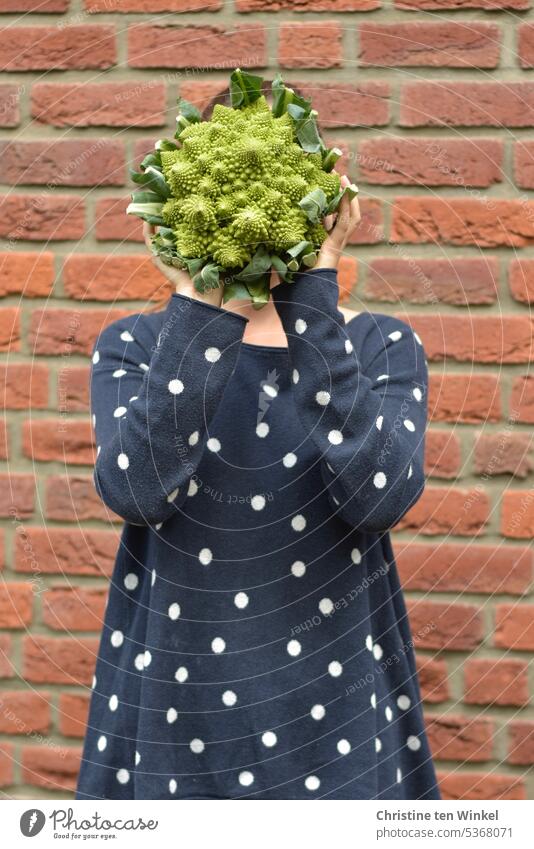 A young woman holds a head of romanesco in front of her face Romanesco Nutrition Vegetarian diet Organic produce Vegetable Food Feminine Young woman
