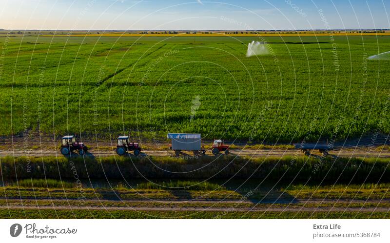 Aerial view on high pressure agricultural water sprinkler, sprayer, sending out jets of water to irrigate corn farm crops Above Agriculture Canal Cereal Coil