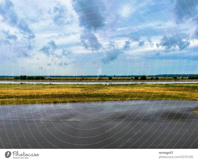 Rain clouds over the Elbe and wet asphalt on the Elbe dike Raincloud River River bank Dike dike top Asphalt cycle path Elbe Cycle Route rainwater Reflection