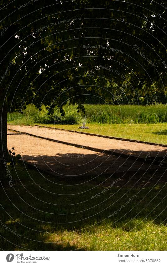 Boccia court between meadow and shade Boules Leisure and hobbies Ball sports Shadow Playing field free time leisure activities Midday sun Shade of a tree fields