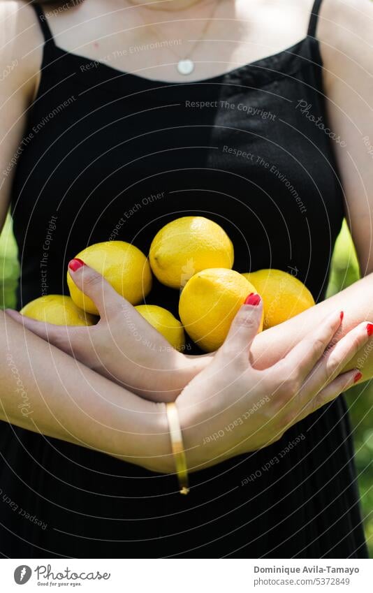 Hands holding lemons Woman's body arms crossed hands Bracelet red nails Lemons Lifestyle female woman citrus citrus fruit Fruit Lemonade Lemon yellow