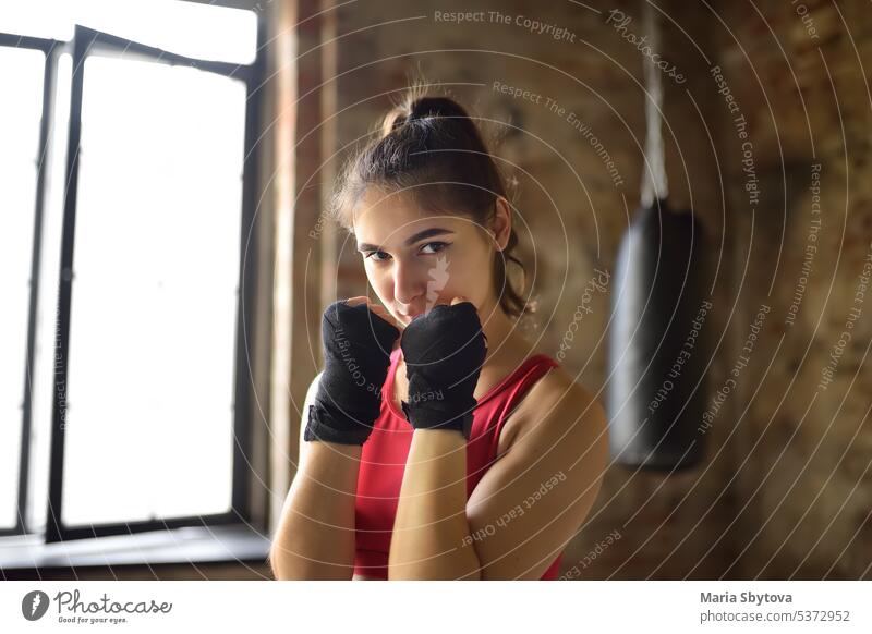 Young woman during a boxing training. Female boxer doing fitness. Regular sports boosts immune system and promote good health and resistance to diseases.