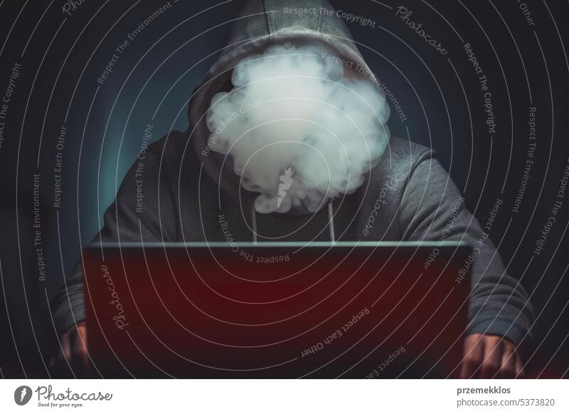 Face covered with smoke. Anonymous man using computer to break security. Cyber security threat. Internet and network security. Stealing private information