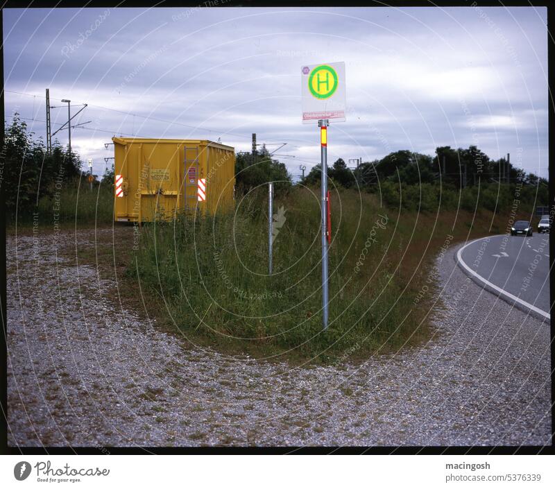 Roadside with container and bus stop Exterior shot Bus stop Bus stop sign Transport Public transit Bus travel Passenger traffic Street Colour photo