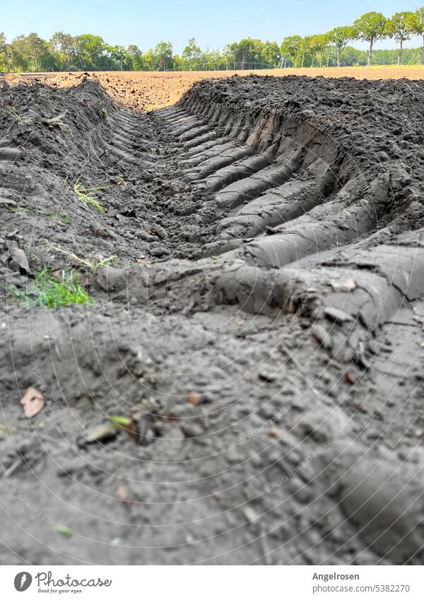 The tractor track leads directly into the fresh field Tractor acre Field lane Clay track Working in the fields Agriculture Skid marks