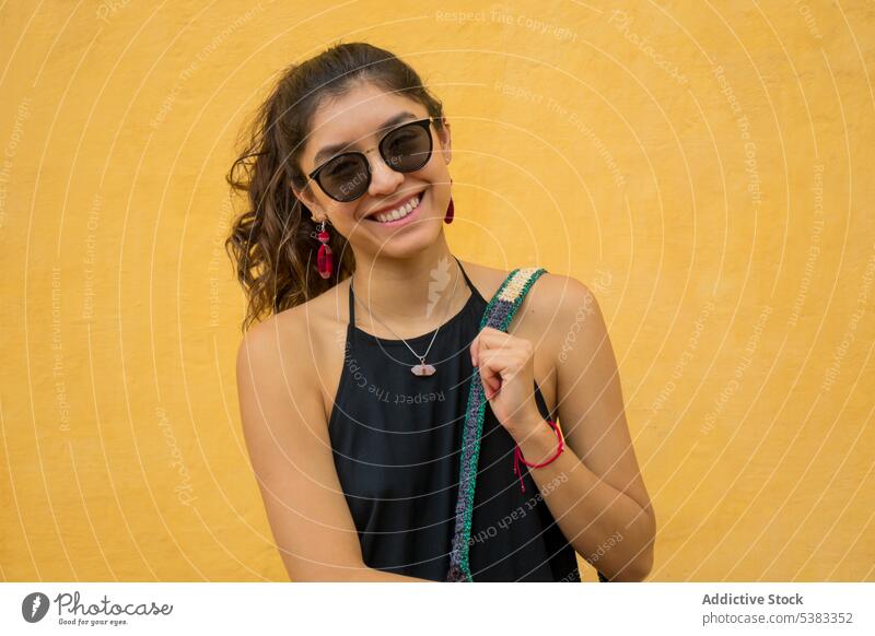 Happy young woman with bag smile happy style outfit wall knitted ornament sunglasses mexico san cristobal de las casas chiapas colorful fashion trendy cheerful
