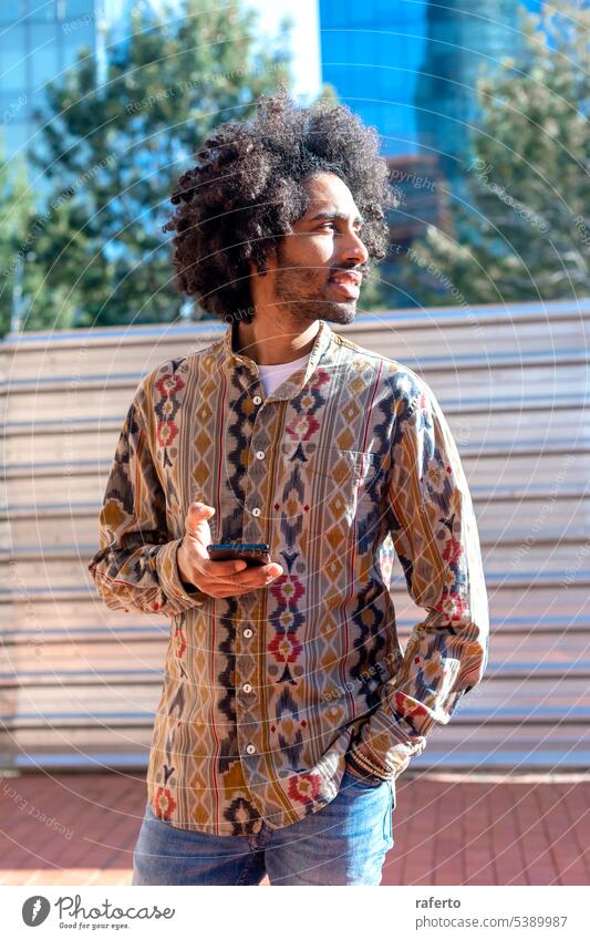 Portrait of handsome afro man using his mobile in the street. Black Casual Clothing Confidence Day Mobile Phone Photography Telephone Typing Wireless Technology