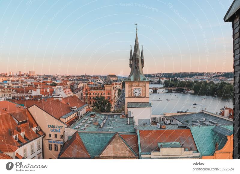 Old Town of Prague under the warm rays of the setting sun illuminating the rooftops of historic buildings in the capital of the Czech Republic. The centre of Prague