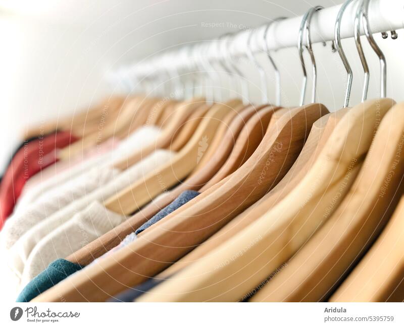 Hangers with clothes hang neatly next to each other on a clothes rail garments Tops hangers Clothes Clothing Fashion Closet Hallstand Arrangement textile