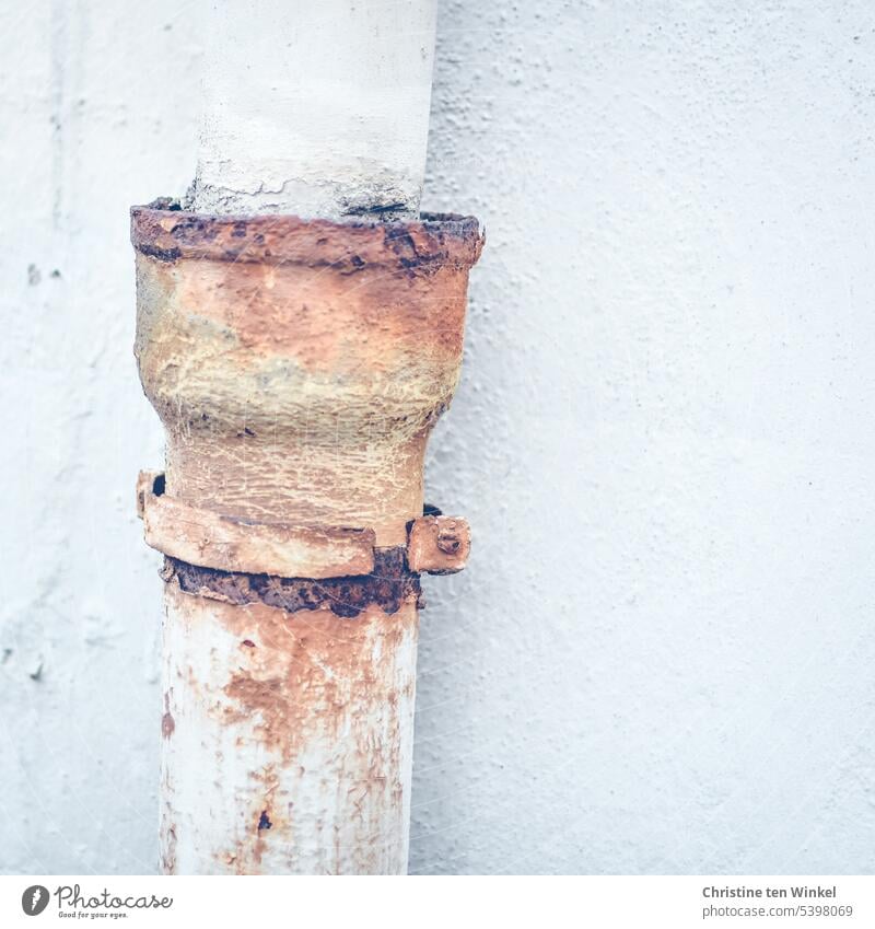 Rusting rain pipe Downpipe Downspout Metal white wall Plastered rusty corroded Ravages of time Old Structures and shapes Decline Close-up Detail Change Trashy