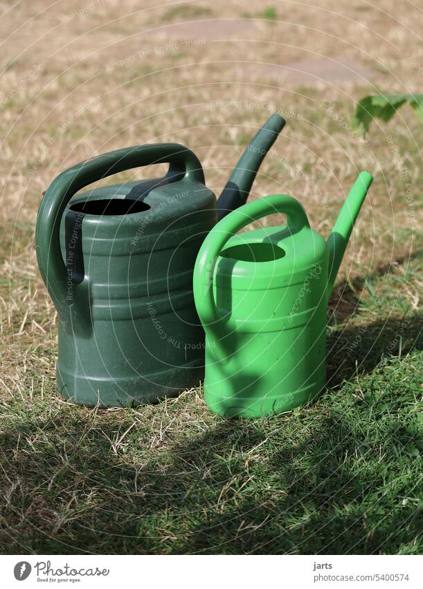 two watering cans on a dried way Watering can Green Small Large Meadow aridity parched Summer Drought lack of water Cast Gardening Irrigation Growth Dry Nature