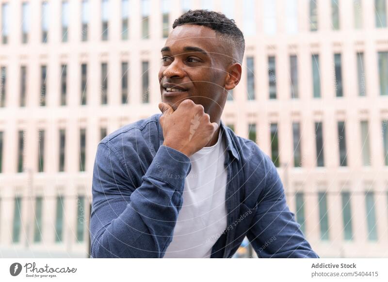 Cheerful black man resting in downtown relax city street friendly smile portrait male african american chill leisure pastime recreation day off summer cityscape