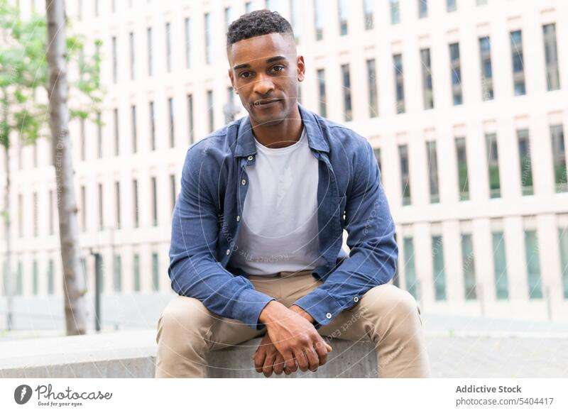 Serious black man resting in downtown relax bench city street portrait male african american chill leisure pastime recreation day off summer cityscape urban