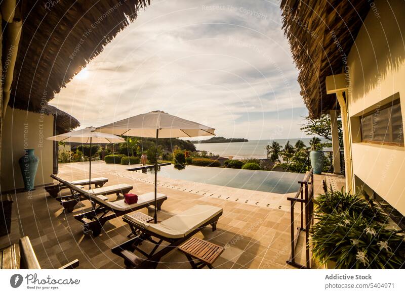 Swimming pool in tropical resort on ocean coast hotel sunbed vacation lush summer lounge greenery exotic recreation holiday umbrella luxury paradise madagascar