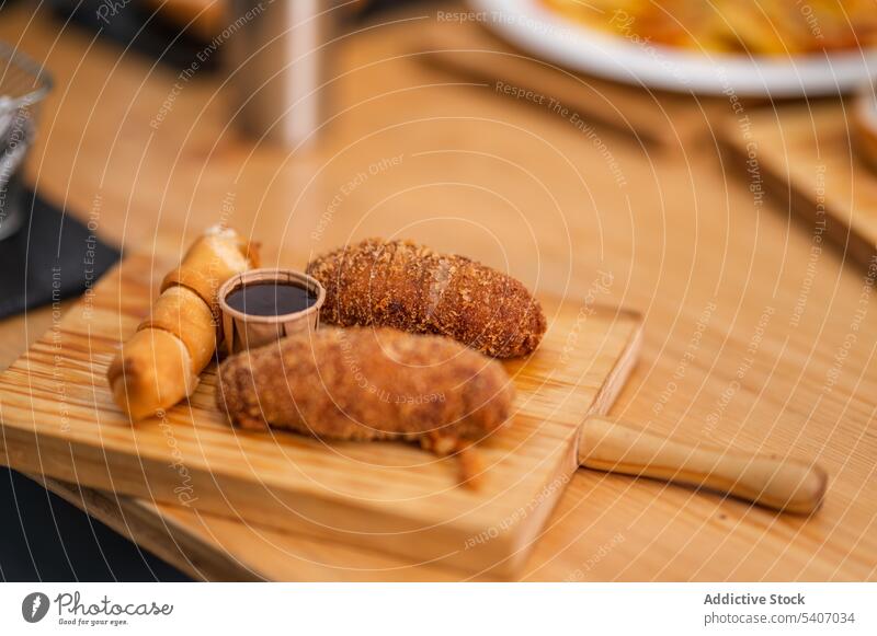 Delicious roll and croquettes on cutting board delicious serve sauce food table restaurant appetizing culinary fresh meal tasty gastronomy savory portion