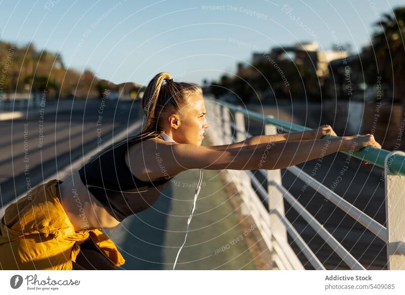 Young woman stretching after working out outdoors at sunset young jogger athlete runner running sport healthy fit fitness athletic training workout exercise