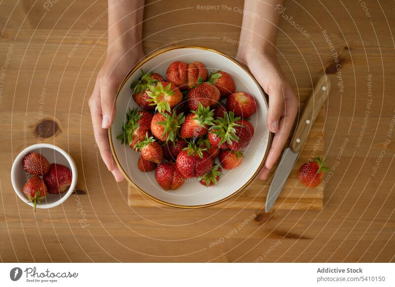 Crop woman holding strawberry in bowl over wooden table person ripe food fresh jam sweet prepare fruit tasty delicious vitamin ingredient dessert piece home