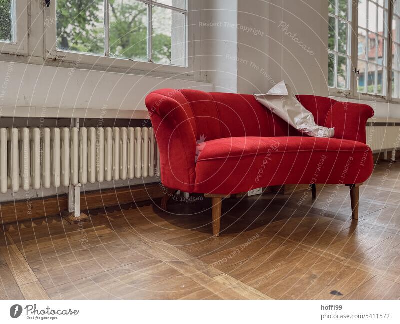red sofa in a room of an old building with beautiful parquet floor Red Sofa Old building Period apartment Parquet floor Living or residing Living room