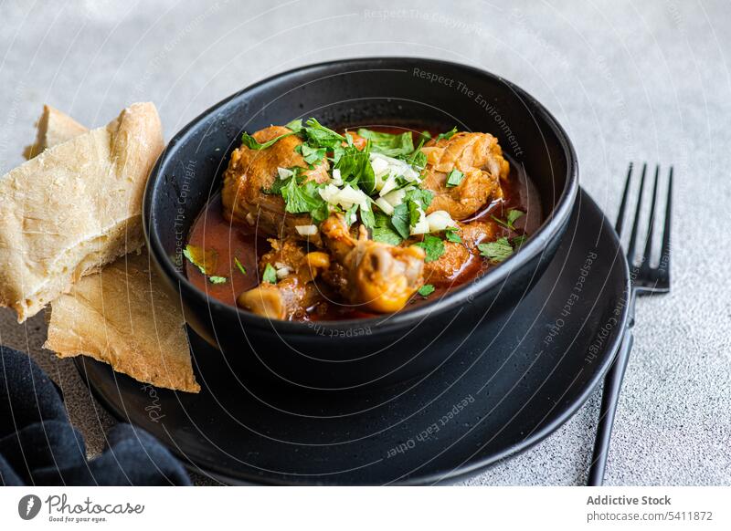 Georgian dish Chakhokhbili is stewed chicken meat in tomato sauce with spices and herbs georgian chakhokhbili herbal plate recipe tradition fork napkin