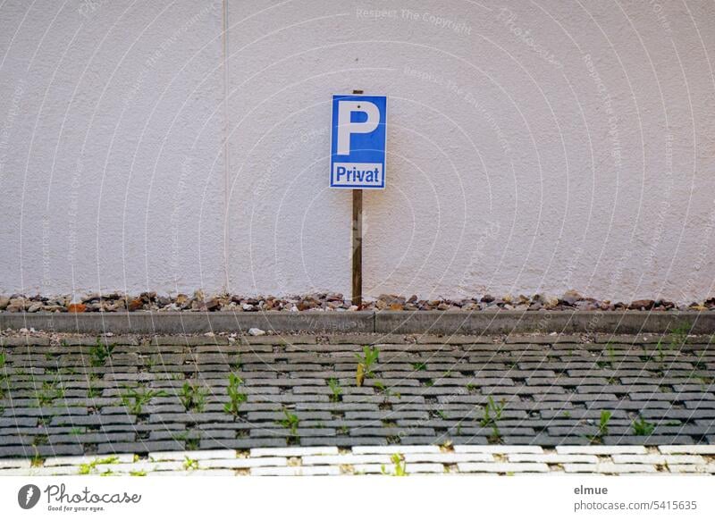 Parking sign with the addition of private in the shade in front of a house wall and behind a paved parking area Parking lot Private private parking