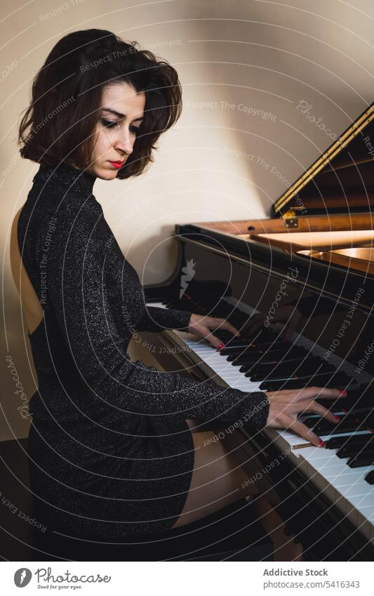 Young woman playing on piano musician young slim elegant room pianist instrument keyboard art sound performance female melody classical closed eyes harmony