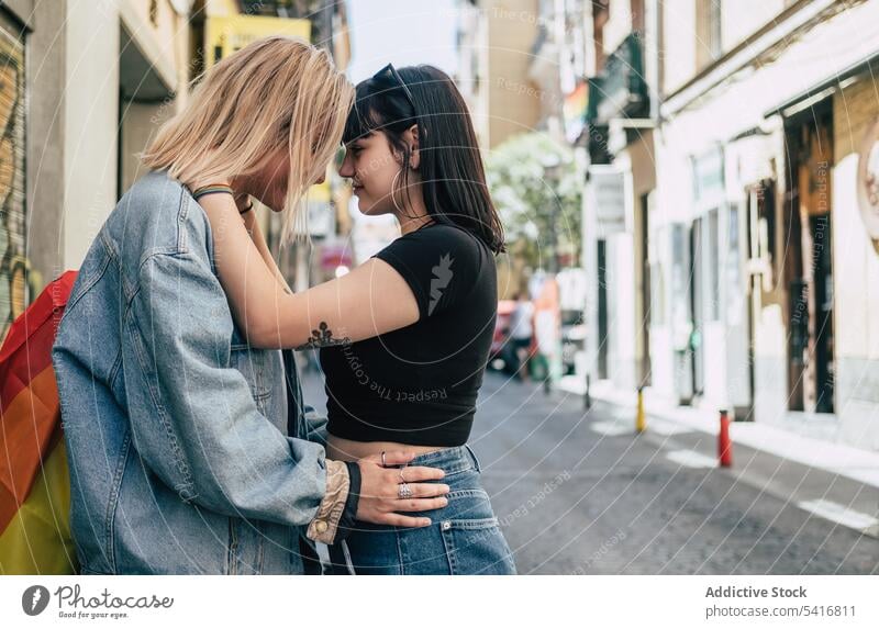 Lesbian couple with LGBT flag standing on street lesbian lgbt hugging happy city young together women casual homosexual pride equality alternative relationship