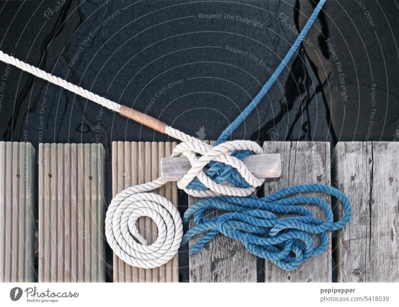 Two ropes attached to a bar, that one nicely rolled, the other chaotically attached. Dew Sailboat Footbridge Harbour Water Watercraft Rope Maritime Navigation