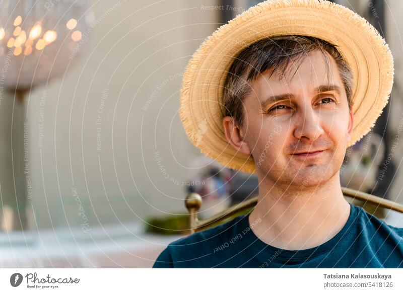 Close-up portrait of a smiling middle-aged man wearing a straw hat and T-shirt close-up hat hat t-shirt looking casual person head one cheerful happiness smile