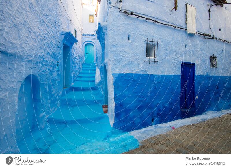 Narrow street and blue houses in Chefchaouen, Morocco chefchaouen morocco rustic travel tourism destination city africa architecture town heritage muslim famous