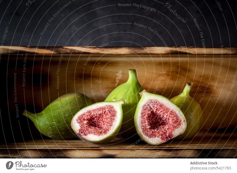 Ripe figs placed on wooden table fruit rustic ripe fresh whole half healthy food vitamin natural organic nutrition tasty arrangement layout composition