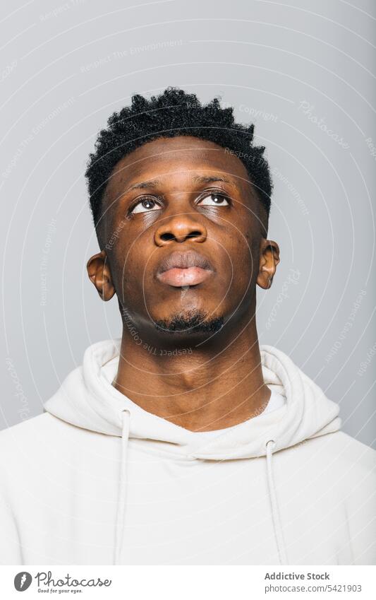 Serious black man in white hoodie serious confident afro portrait human face gaze male young african american stare hipster informal model masculine brutal