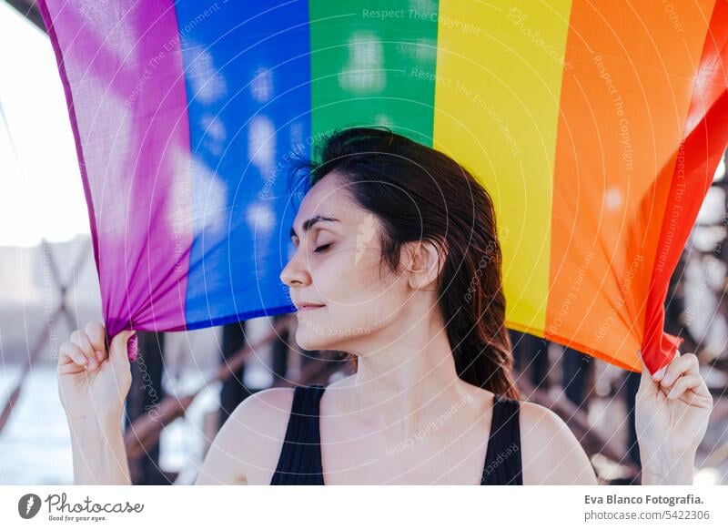 young beautiful woman holding a rainbow gay flag outdoors. LIFESTYLE an pride concept. love is love day community proud sex life festival couple freedom june