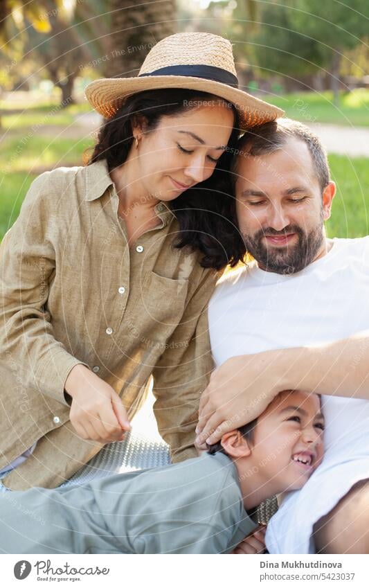 happy family smiling with a son in park outdoors in summer mom dad father mother parenthood parents fatherhood motherhood love together child childhood bonding