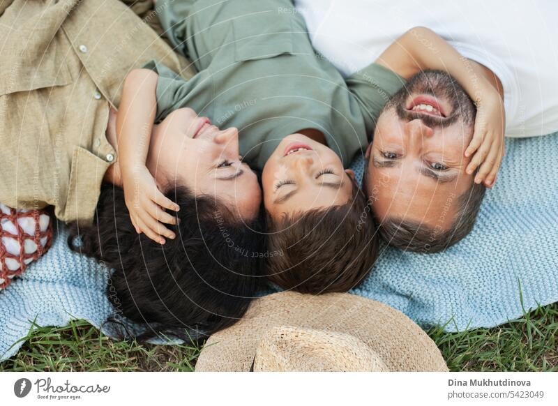 happy family smiling with a son in park outdoors in summer faces closeup mom dad father mother parenthood parents fatherhood motherhood love together child