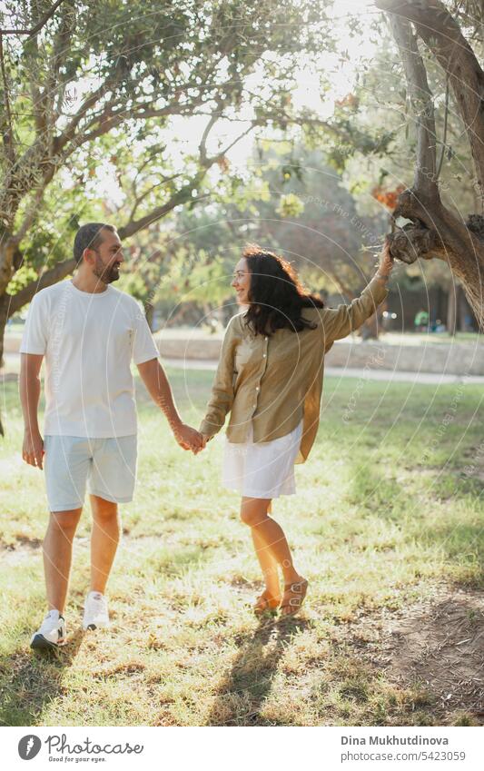 couple hugging in summer park in olive grove in green olive color palette. Earthy tones love and couple goals aesthetic. family together Olive grove linen