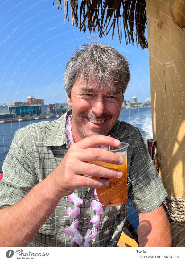 Man enjoying a drink on a tiki boat tour outdoors scenery water man travel tourism traveler vacation scenic trip Drink Cocktail