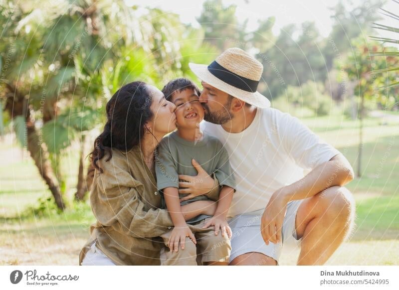 happy family smiling with a son in park outdoors in summer mom dad father mother parenthood parents fatherhood motherhood love together child childhood bonding