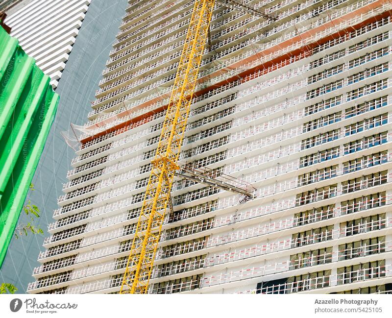 Modern unfinished skyscraper with a lifting crane. apartment architectural architecture background balcony block building business cement city cityscape